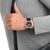 Mondaine Stop2Go-Uhr am Handgelenk mit schwarzem Lederarmband und schwarzem Zifferblatt