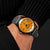 Orologio da uomo al polso: quadrante arancione, cinturino in pelle grigia con fori decorativi