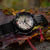Herrenuhr mit grauem Ziffernblatt, schwarzem Armband und roten Minutenmarkierungen