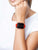 Smartwatch con cinturino rosso al polso, display quadrato con numeri