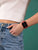 Smartwatch con cinturino rosso al polso, display quadrato nero