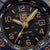 Primo piano del quadrante: orologio da uomo con lancette dorate, datario, indici luminescenti e "200 metri".