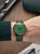 Orologio da uomo al polso: quadrante verde, cinturino in pelle verde, cassa color oro rosa.