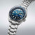 Herrenuhr schrägansicht: blaues Zifferblatt, Lünette und Edelstahlarmband
