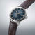 Orologio da uomo con quadrante blu, cinturino in pelle marrone e lunetta distintiva