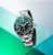 Orologio da uomo, vista laterale, con quadrante verde, cinturino in acciaio argentato e corona