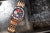 Herrenarmbanduhr mit roségoldfarbenem Metallarmband und rotem Zifferblatt, schräger Blick