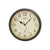 Wanduhr mit beigem Zifferblatt, schwarzen Zeigern, römischen Ziffern und dunklem Metallgehäuse