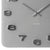 Nahaufnahme: graue Wanduhr mit offenen Zahlen und „KARLSSON“ Schriftzug im Gehäuse