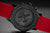 Retro orologio da uomo con incisione sul retro, cassa nera e cinturino rosso