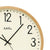 Orologio da parete con quadrante beige, lancette nere e cornice in legno chiaro, AMS.