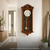Holz-Wanduhr an der Wand, rundes Ziffernblatt mit Pendelgewicht und vergoldeten Akzenten.