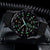 Orologio da uomo con cassa rotonda nera e numeri luminescenti, cinturino in tessuto nero