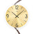 Orologio da parete in primo piano: quadrante color oro con numeri e lancette neri