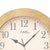 "Vista dettagliata orologio da parete: cornice beige, quadrante bianco con numeri romani e lancette"