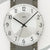 Detail der Wanduhr: Aluminium-Zifferblatt mit AMS, römische Zahlen und Zeigern