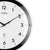 Detail der Wanduhr: silberner Rand, schwarzer Ring, Ziffern 2–4 und Zeiger sichtbar