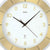 Detail der Wanduhr: weißes Ziffernblatt mit arabischen Ziffern, goldfarbene Fassung