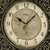 Nahaufnahme der Funk-Wanduhr: Ziffernblatt mit AMS-Logo, goldenem Ring und schwarzen Zeigern