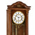 Orologio da parete in legno nel dettaglio: quadrante con numeri romani e asta a pendolo color oro.