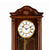 Orologio da parete in legno marrone in primo piano con numeri romani e area pendolo dorata