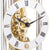 Meccanismo di orologio da tavolo con ingranaggi color oro e numeri romani su quadrante bianco